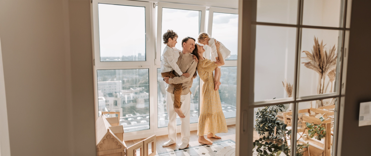 Gelukkig gezin lacht en knuffelt in de woonkamer.