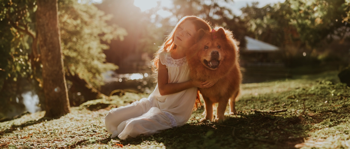 Meisje knuffelt met haar hond buiten.