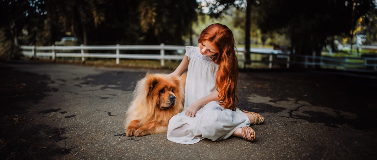 Meisje zit met haar hond op straat.