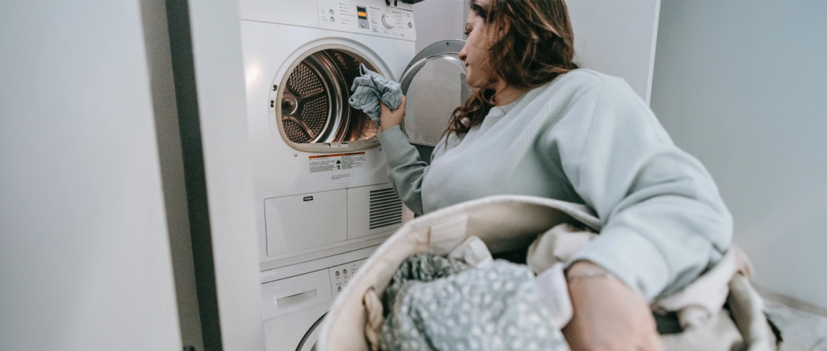 Vrouw doet de was met een wasmand.